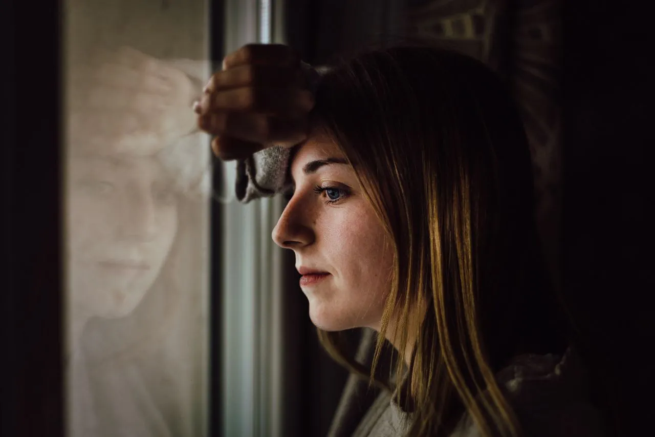 Pensive woman by a window